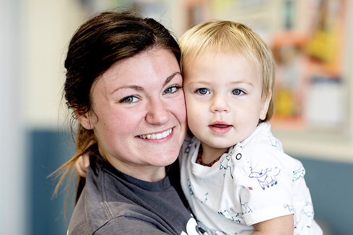 Teacher holding little boy smiling